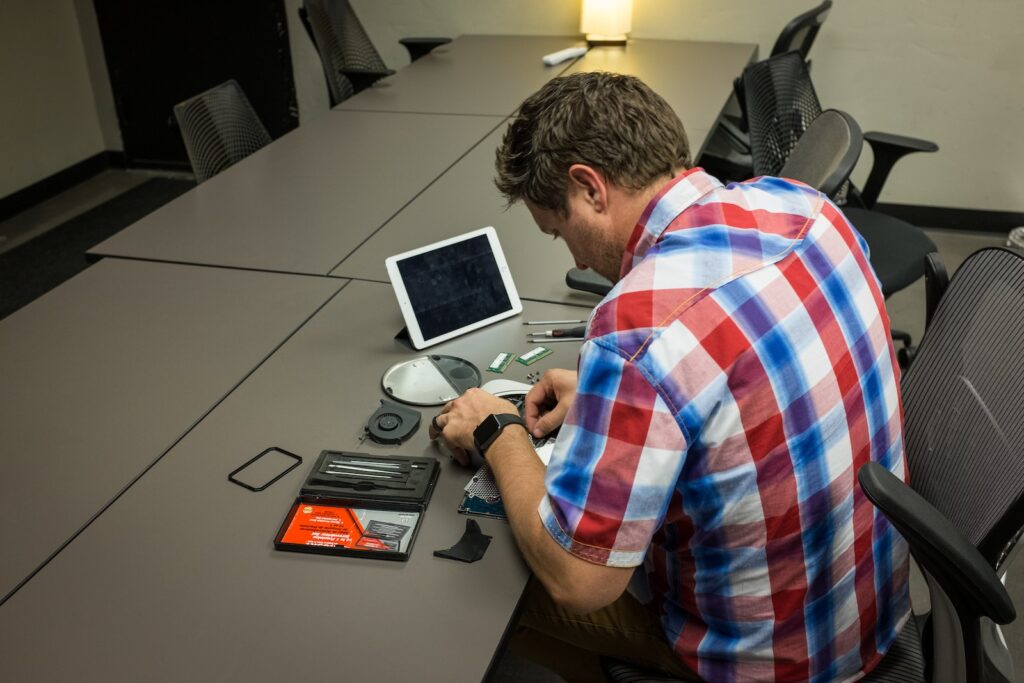 man sitting on chair and writing on desk